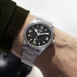 Maennlicher Arm traegt TUDOR Ranger Uhr in Stahl mit schwarzem Zifferblatt am Handgelenk