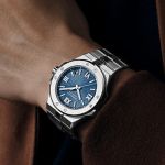 Chopard Alpine Eagle Uhr mit Gehaeuse und Armband in Stahl und blauem Zifferblatt mit roemischen Ziffern am Herrenhandgelenk getragen