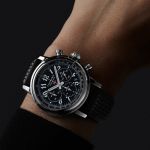 Chopard Mille Miglia Chronograph mit Gehaeuse in Stahl, schwarzem Zifferblatt mit arabischen Ziffern und schwarzem Kautschukarmband getragen an einem Herrenhandgelenk