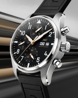 IWC Chronograph im Edelstahlgehäuse mit schwarzem Zifferblatt, goldenen Akzenten und schwarzem Kautschukarmband, inspiriert vom APXGP Rennsportdesign.