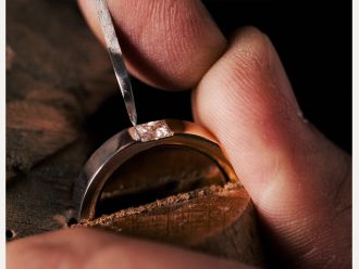 Goldschmied setzt Diamanten von Hand in individuell gefertigten Verlobungsring im Meisteratelier M&uuml;hlbacher