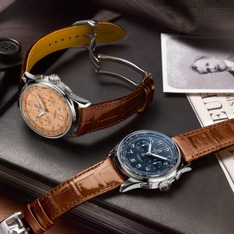 Zwei Breitling Premier Chronographen mit Stahlgehaeusen, Zifferblaetter in kupfer und blau und braunen Lederarmbaender auf Lifestylehintergrund