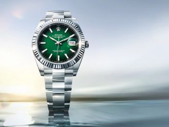Rolex Datejust mit gr&uuml;nem Zifferblatt, geriffelter Wei&szlig;gold-L&uuml;nette und Oyster-Band auf hellem Hintergrund