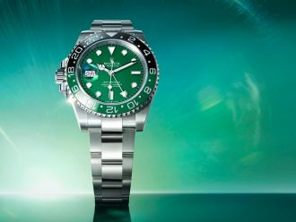 Panoramaaufnahme der Rolex GMT-Master II mit grünem Zifferblatt und schwarzer Cerachrom-Lünette steht im Mittelpunkt auf smaragdgrünem Hintergrund mit Lichteffekt.