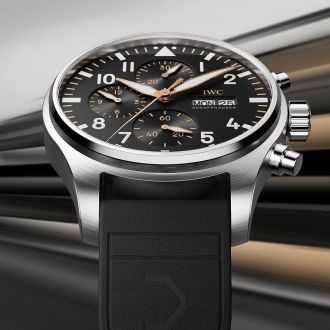 IWC Pilot’s Watch Chronograph aus Edelstahl mit schwarzem Zifferblatt, goldenen Details und schwarzem Kautschukarmband, inspiriert vom APXGP-Rennsportstil.