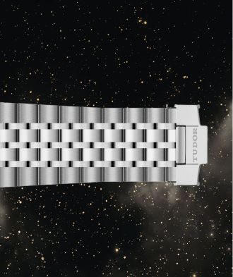 Detailaufnahme des fünfreihigen Edelstahlarmbands der TUDOR 1926 Luna Uhr mit TUDOR-Schließe vor Sternenhimmel.