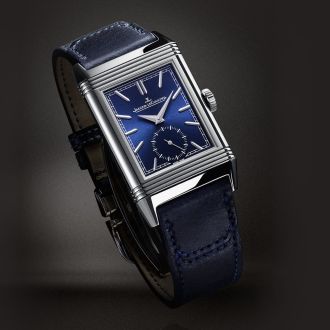 Jaeger-LeCoultre Reverso Uhr in Stahl mit blauem Zifferblatt und Lederarmband vor grauem Hintergrund