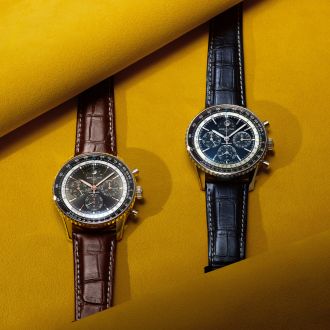 Breitling Navitimer B19 Chronograph Perpetual Calendar mit blauem und schwarzem Zifferblatt auf Lederarmband vor gelbem Hintergrund