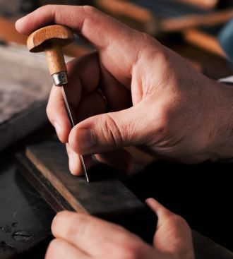 Goldschmied bei der Arbeit im Atelier von Mühlbacher, feine Handwerkskunst in Detailaufnahme.