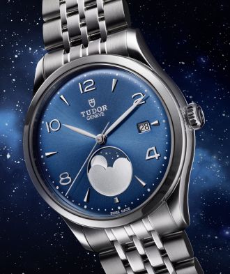 TUDOR 1926 Luna mit blauem Zifferblatt, Mondphasenanzeige bei 6 Uhr und Edelstahlarmband vor nachtblauem Sternenhintergrund.
