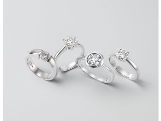 Vier Verlobungsringe mit unterschiedlichen Fassungen &ndash; Spannfassung, hohe Krappenfassung, Zargenfassung und klassische Solit&auml;r-Krappenfassung in hochwertiger Studioaufnahme