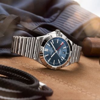 Breitling Chronomat Uhr in Stahl mit blauem Zifferblatt seitlich auf Lifestylehintergrund liegend