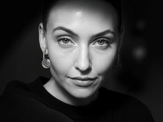 Frau mit Danuvina by Mühlbacher Ohrringen aus der Mill River Kollektion in Schwarz-Weiß-Porträtaufnahme.