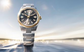 Rolex Oyster Perpetual Armbanduhr in Edelstahl und Gold mit grauem Zifferblatt vor dynamischem, lichtdurchflutetem Hintergrund