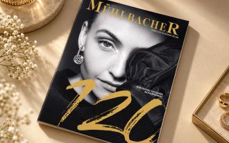 Hausmagazin von Juwelier M&uuml;hlbacher in Regensburg, auf elegantem beigefarbenem Untergrund arrangiert.