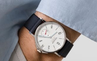 Handgelenk mit NOMOS Glashütte Ahoi Uhr – elegantes neues Ahoi Modell mit weißem Zifferblatt und Textilarmband
