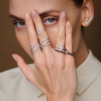 Mehrere moderne Ringe aus Wei&szlig;gold und Gold mit Diamanten, stilvoll an einer Hand getragen, Nahaufnahme.