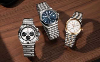 Breitling Chronomat Kollektion mit Chronomat B01 42 Chronograph, Automatic 40 mit blauem Zifferblatt und Automatic 36 in Bicolor auf edler Holzoberfl&auml;che.