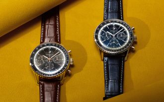 Breitling Navitimer B19 Chronograph Perpetual Calendar mit blauem und schwarzem Zifferblatt auf Lederarmband vor gelbem Hintergrund