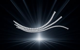 Drei funkelnde Diamantarmbänder in Weißgold aus der Anniversary Kollektion von Atelier Mühlbacher, elegant geschwungen vor dunklem Hintergrund mit Lichtstrahlen im Zentrum.