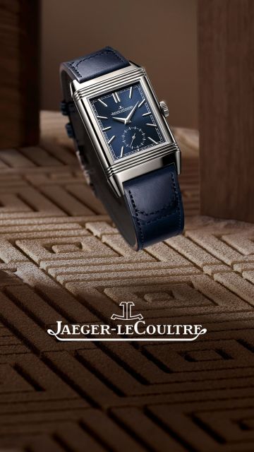 Seitliche Ansicht der Jaeger-LeCoultre Reverso Uhr mit blauem Zifferblatt und Lederarmband, stilvoll inszeniert zwischen Holzelementen mit prominentem Markenlogo rechts.