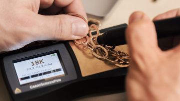 Zertifizierter Goldexperte bei Juwelier Mühlbacher prüft Schmuckkette auf Feingehalt – transparenter Goldankauf in Regensburg.