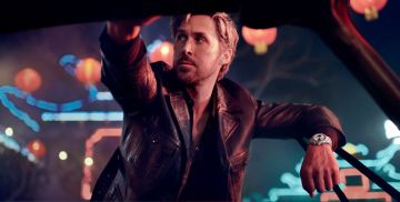 Ryan Gosling an einer Autotuer lehnend traegt am Handgelenk einen Carrera Chronographen von TAG Heuer in Stahl mit silberschwarzem Panda-Zifferblatt