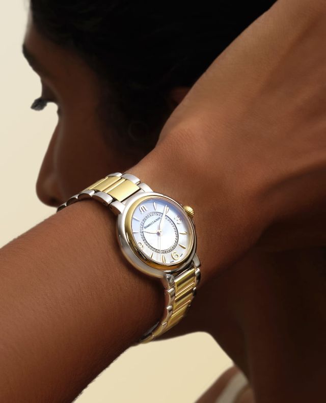 Weibliches Model mit Fiaba Uhr von Maurice Lacroix in Gelbgold und Stahl am Handgelenk