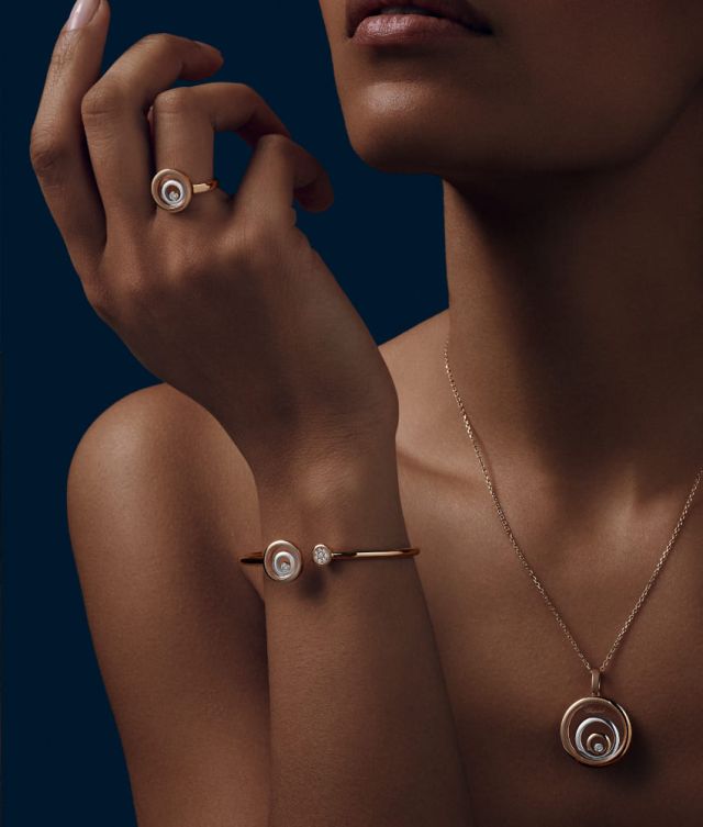 Chopard Happy Spirit Ring, Armreif und Halskette mit Anhaenger jeweils in Weissgold und Rosegold mit je einem beweglichen Diamanten von einem Model getragen
