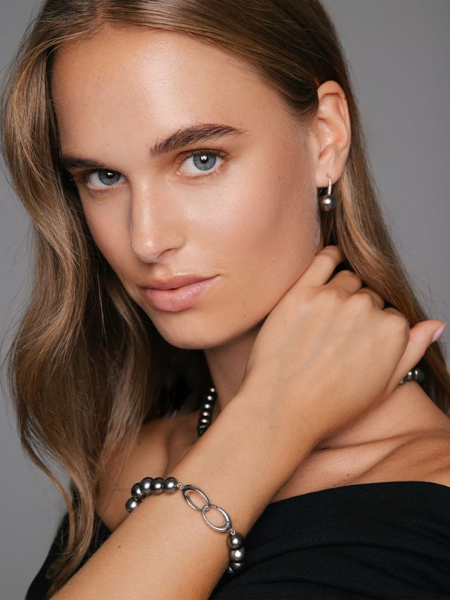 Weibliches Model trägt Ohrhänger, Perlarmband und eine Perlenkette mit Tahitiperlen aus der Urban Nights Kollektion von Yana Nesper.