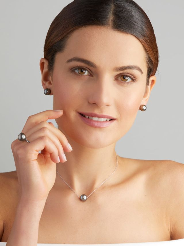 Frau mit passendem Schmuck-Set aus Tahiti-Perlen: Halskette, Ohrringe und Ring, zeitloser und stilvoller Look.