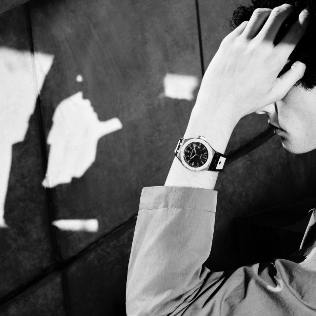 Porträtartige Szene: Mann berührt sein Gesicht, Maurice Lacroix AIKONIC Automatikuhr im Fokus, exklusives Lifestyle-Uhrenfoto.