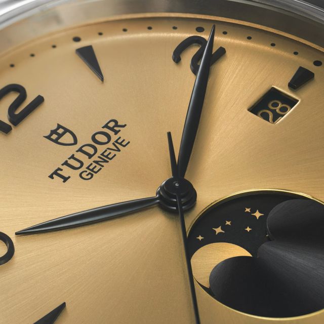 Nahaufnahme des Zifferblatts der TUDOR 1926 Luna in Champagner mit schwarzer Mondphasenanzeige, applizierten Indizes und Datumsfenster.