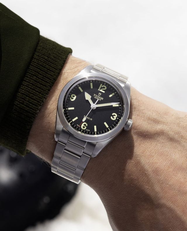 Maennlicher Arm traegt TUDOR Ranger Uhr in Stahl mit schwarzem Zifferblatt am Handgelenk