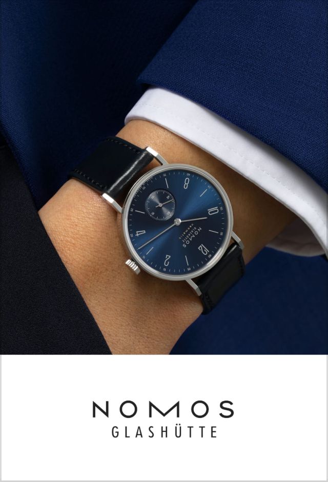 NOMOS Glashuette Tangente Uhr in Stahl mit blauem Zifferblatt und Lederarmband an einem maennlichen Handgelenk