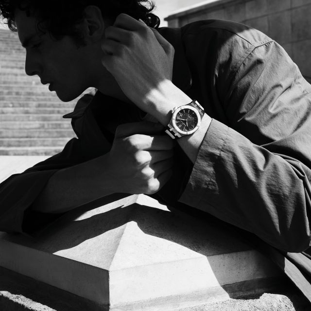 Eleganter Mann trägt Maurice Lacroix AIKONIC Uhr, Nahaufnahme am Handgelenk in Schwarz-Weiß, luxuriöse Schweizer Automatikuhr.