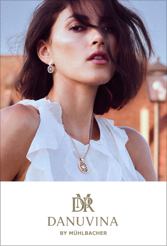 Model mit kurzem, dunklem Haar tr&auml;gt goldene Ohrringe und eine passende Halskette mit filigranem Anh&auml;nger aus der Schmuckkollektion DANUVINA by M&uuml;hlbacher.
