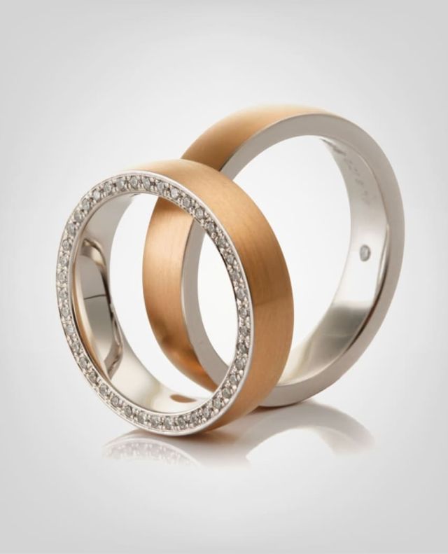 Trauringe aus dem Muehlbacher Meisteratelier, aussen Rosegold und innen in Weissgold, der Damenring ist zusaetzlich seitlich komplett mit Diamanten besetzt