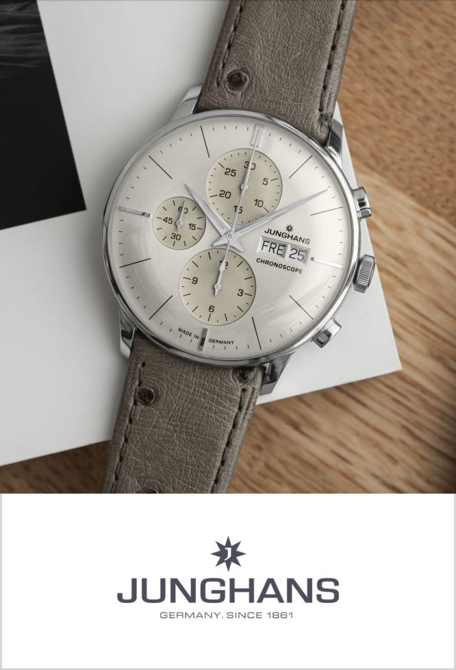 Junghans Meister Chronograph in Stahl mit grauem Zifferblatt seitlich auf einem Buch liegend