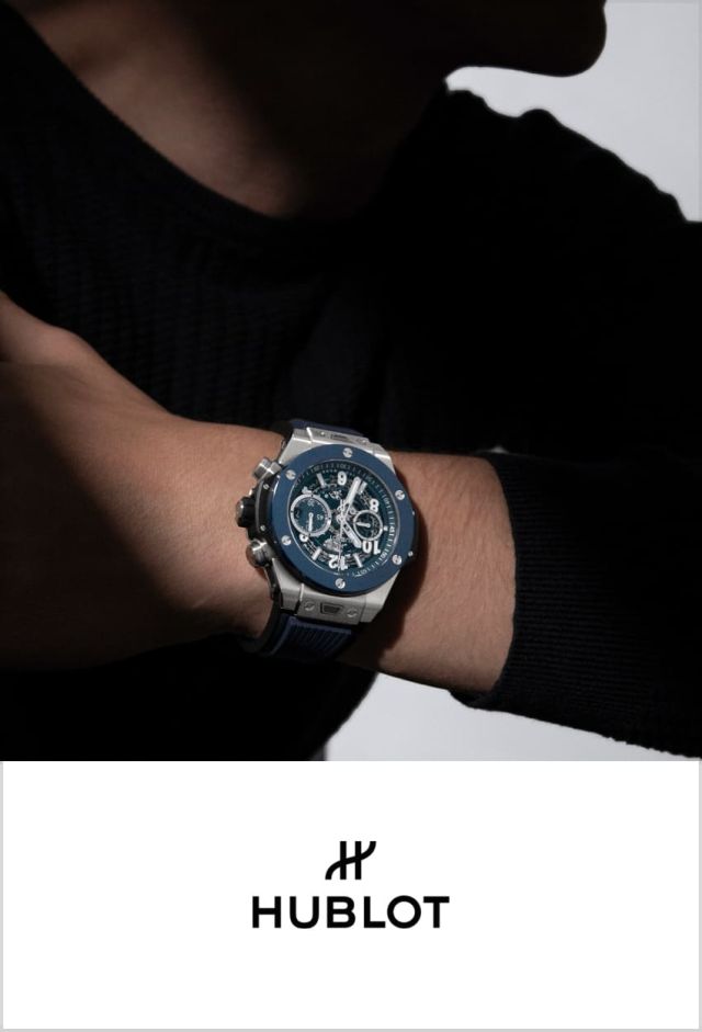 Hublot Big Bang Chronograph am Handgelenk eines Mannes in schwarzem Pullover, Nahaufnahme mit dunklem Hintergrund.