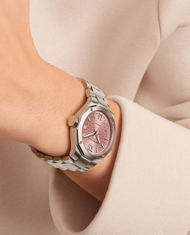 Weibliches Model mit Maurice Lacroix Aikon Uhr in Stahl mit rosa Zifferblatt am Handgelenk