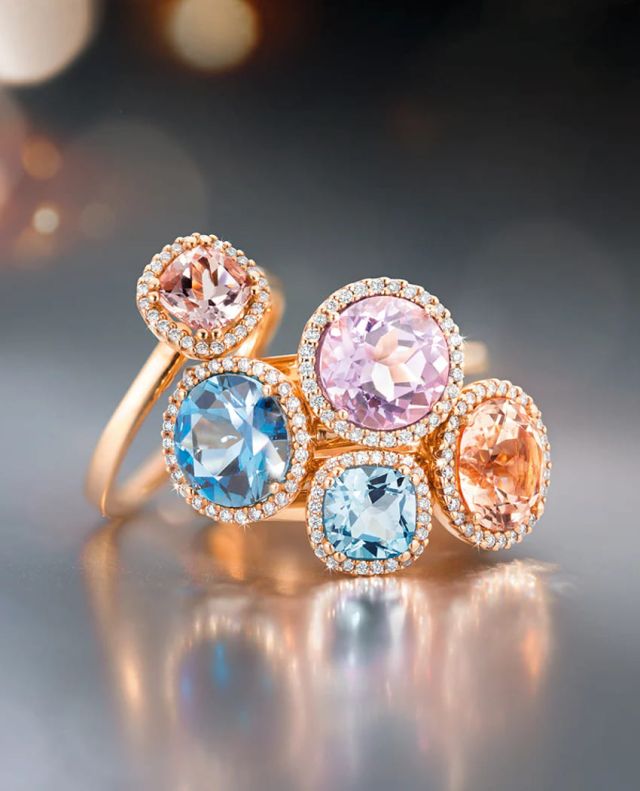 Capolavoro Espressivo Ringe in Rosegold mit Diamanten und unterschiedlichen Farbedelsteinen auf grauem Hintergrund