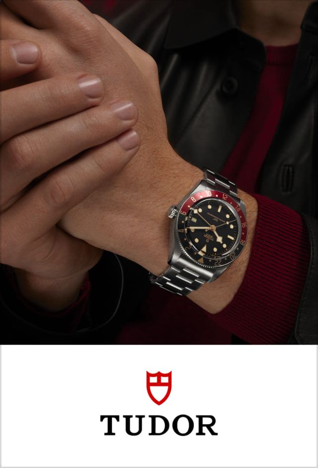 Maennliches Model traegt eine Black Bay von Tudor in Stahl mit schwarz-roter Luenette und schwarzem Zifferblatt am Handgelenk