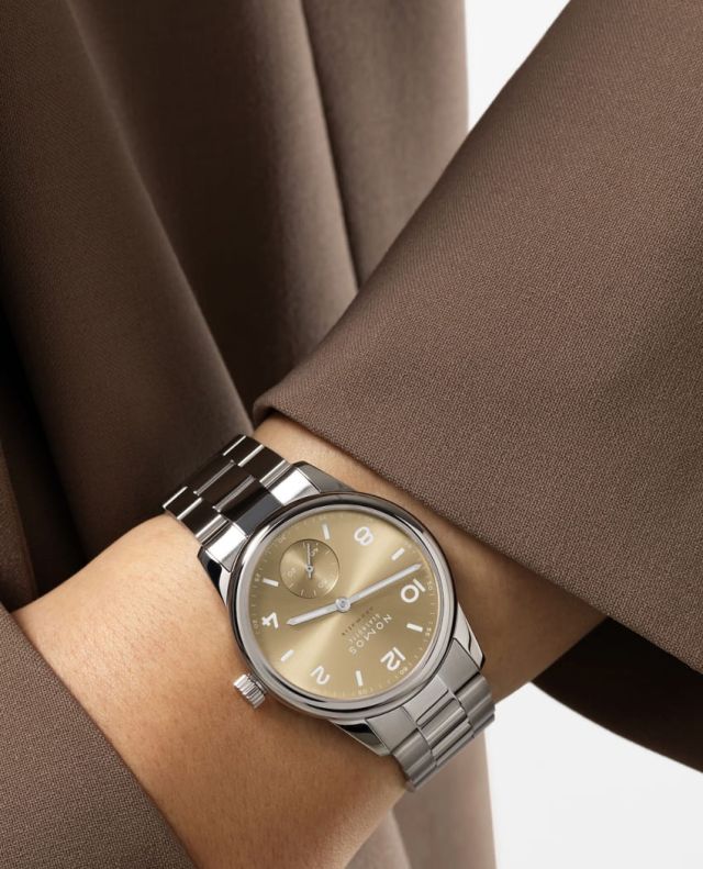 NOMOS Glashuette Club Sport Neomatik Uhr in Stahl mit champagnerfarbenem Zifferblatt an einem Damenhandgelenk