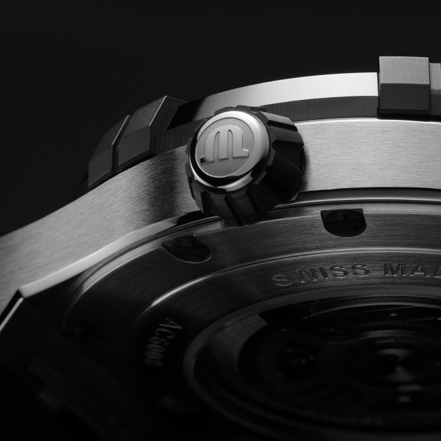 Detailaufnahme Maurice Lacroix AIKONIC Gehäuse in Edelstahl, Aikonic Uhr mit markanter Krone mit Maurice Lacroix Icon und Swiss Made Gravur am Gehaeuseboden.