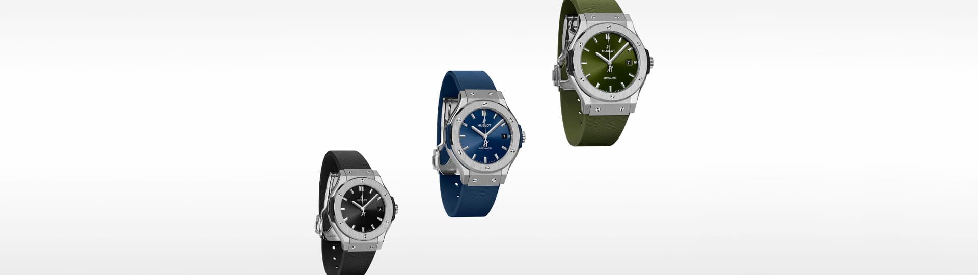 Drei Hublot Classic Fusion Uhren mit Edelstahlgehäuse und Armbändern in Schwarz, Blau und Olivgrün vor weißem Hintergrund schwebend angeordnet.