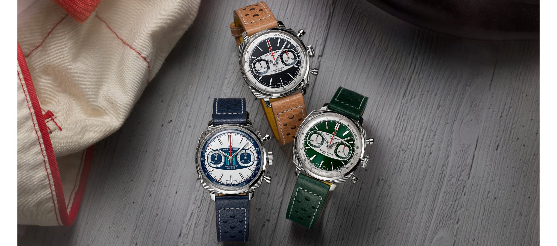 Drei Breitling Top Time Racing Uhren nebeneinander liegend vor Lifestylehintergrund