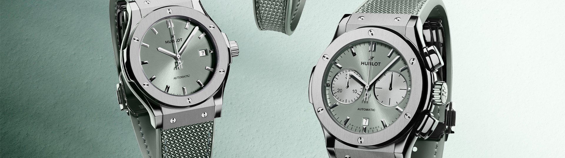 Hublot Classic Fusion Automatic und Chronograph mit salbeifarbenem Zifferblatt und Textilarmband, Edelstahlgehäuse vor hellem salbeifarbenem Hintergrund