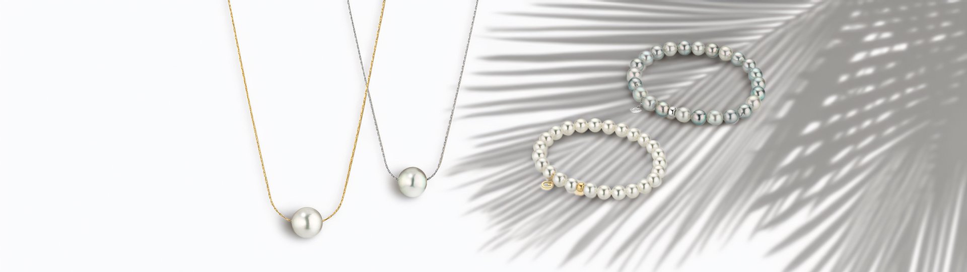Halsketten und Armbänder der Gellner Pure Kollektion mit weißen und grauen Perlen auf hellem Hintergrund.