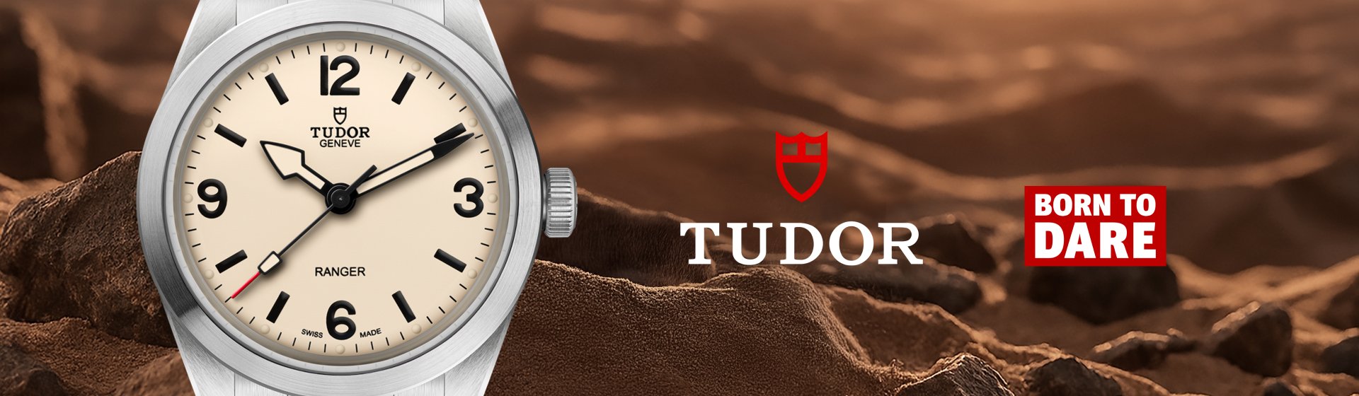 Detailansicht der TUDOR Ranger mit neuem Zifferblatt in „Dust“, vor einer sandigen Felslandschaft, daneben TUDOR Logo und „Born To Dare“-Slogan.